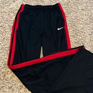 black nike sweatpants with red stripes on the sides